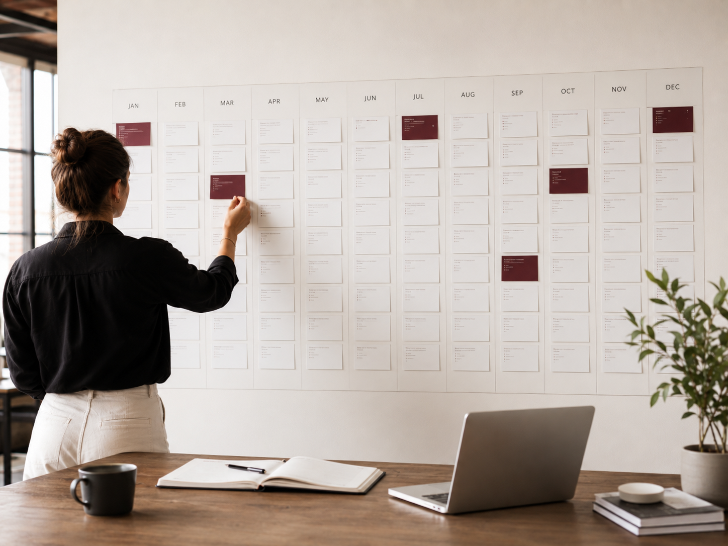 An annual event calendar laid out month by month across a studio wall.
